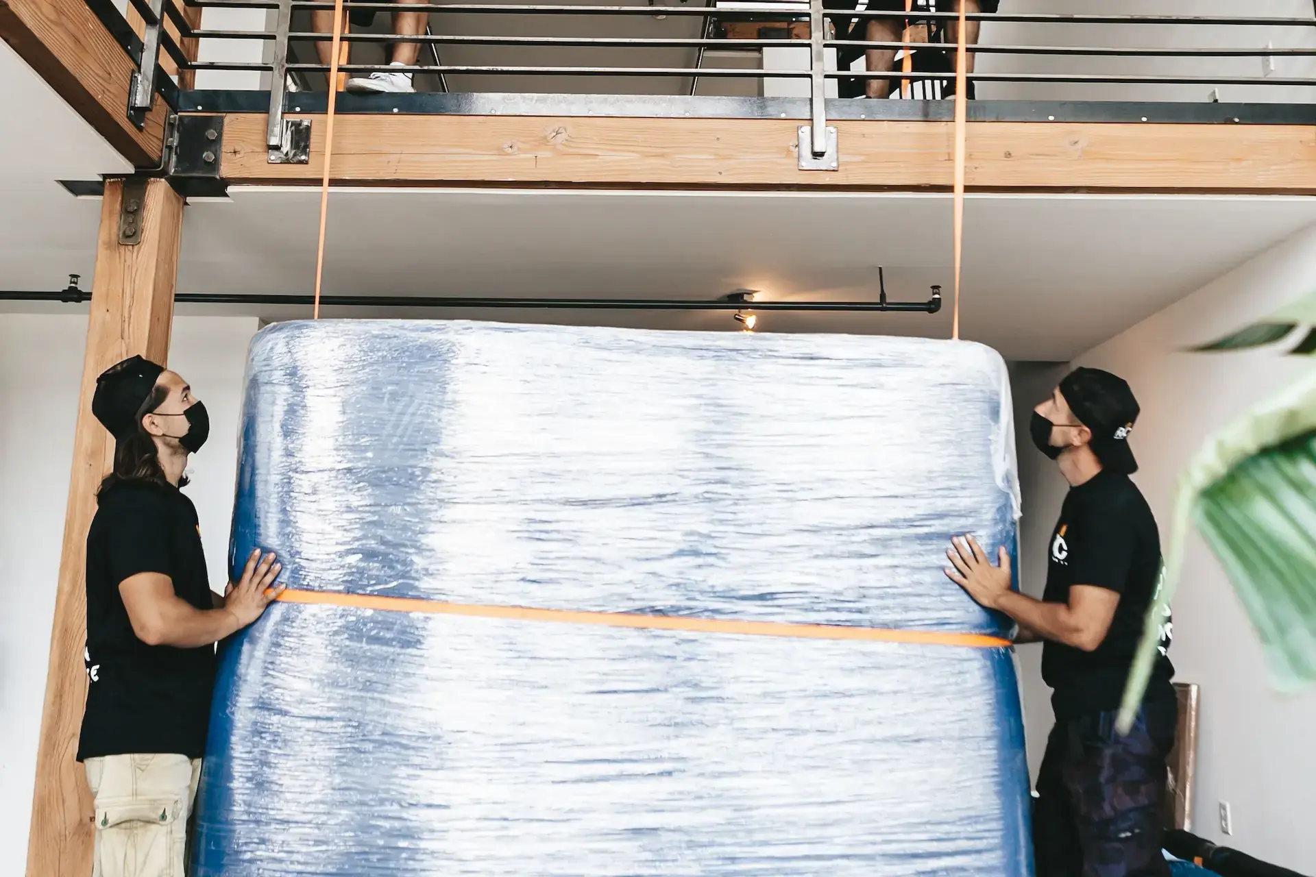 Movewala crew moving a wrapped piece of furniture